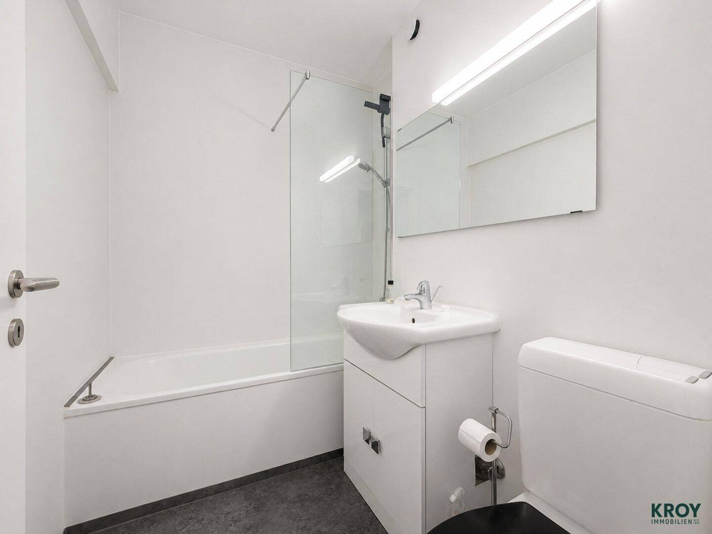 Modernes Badezimmer mit Badewanne, Duschabtrennung und Waschbeckenunterschrank.