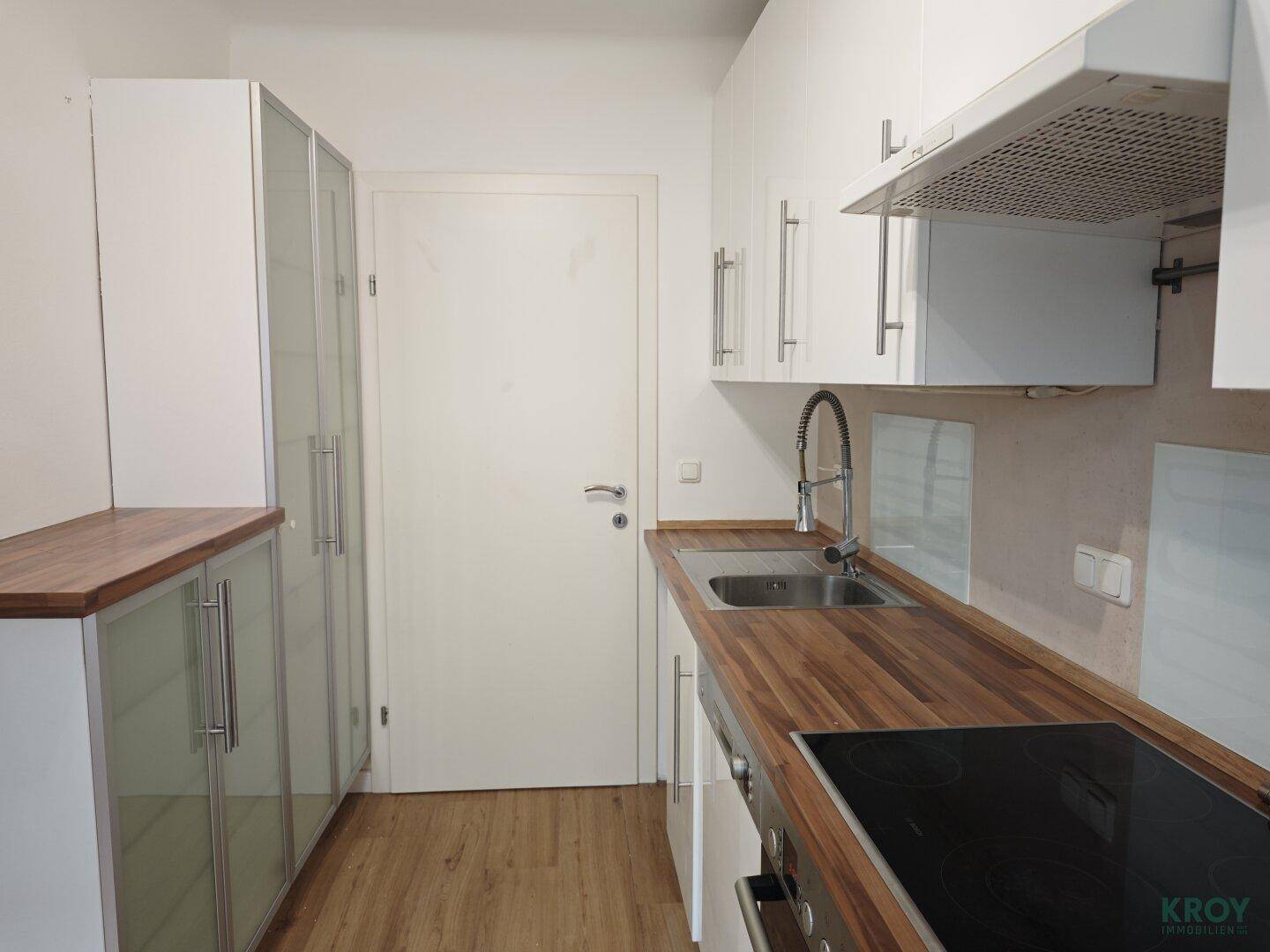 Funktionale Küche mit Spülbecken, modernen Armaturen und viel Stauraum in den Schränken.