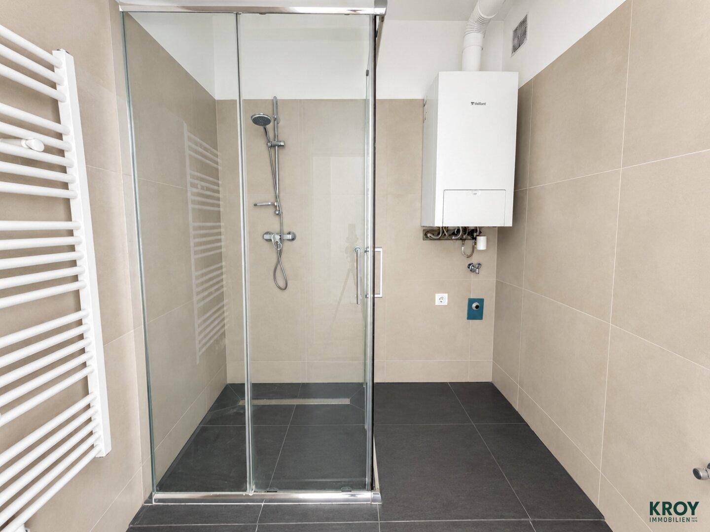 Modernes Badezimmer mit begehbarer Dusche, Fliesenboden und Handtuchheizkörper.
