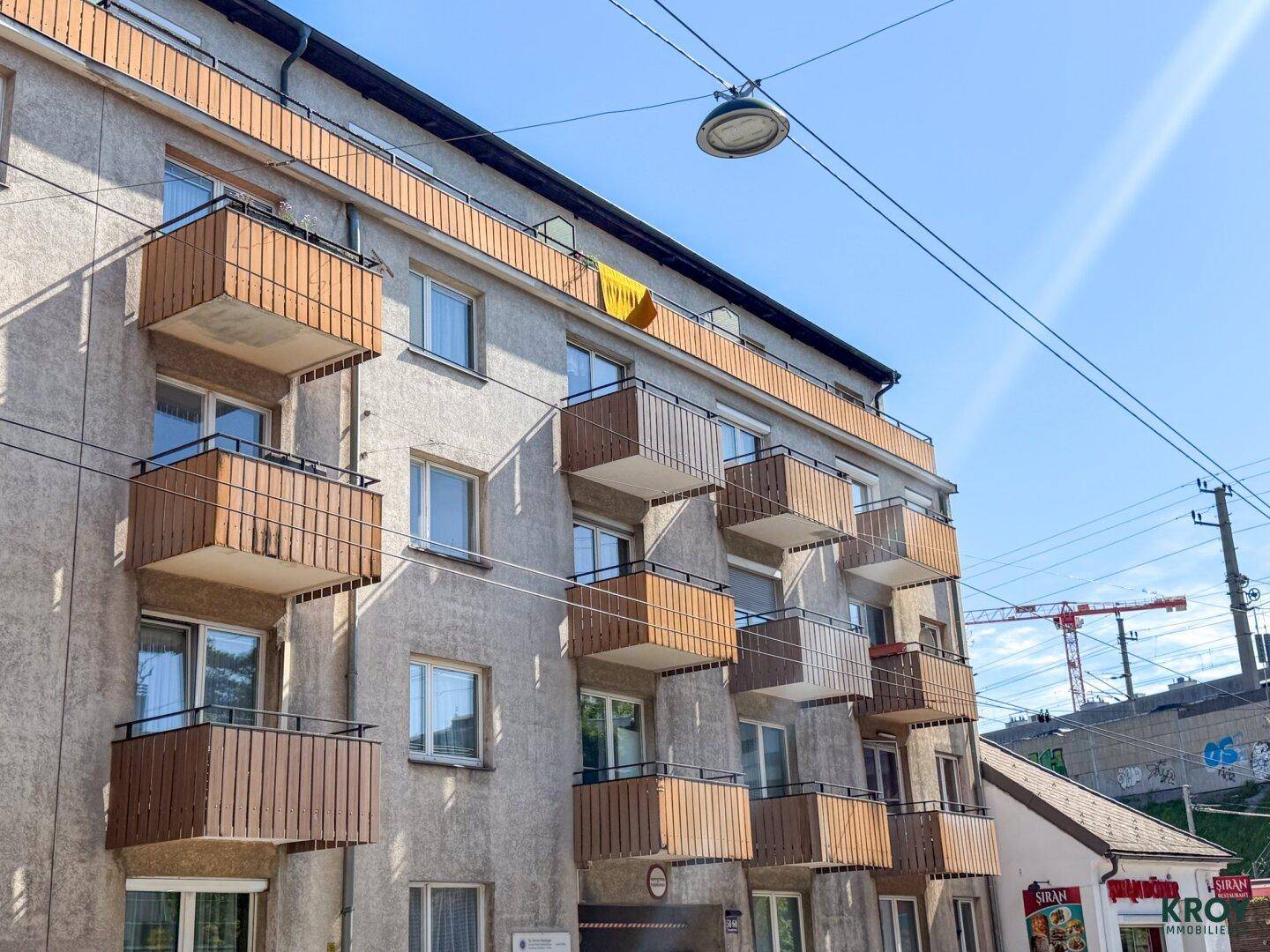 Außenansicht eines Mehrfamilienhauses mit mehreren Balkonen und moderner Architektur.