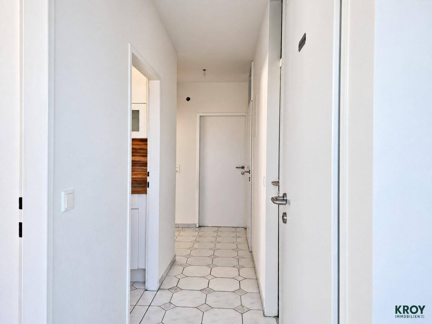 Heller Flur mit geometrischen Fliesen und Zugang zu weiteren Räumen der Wohnung.