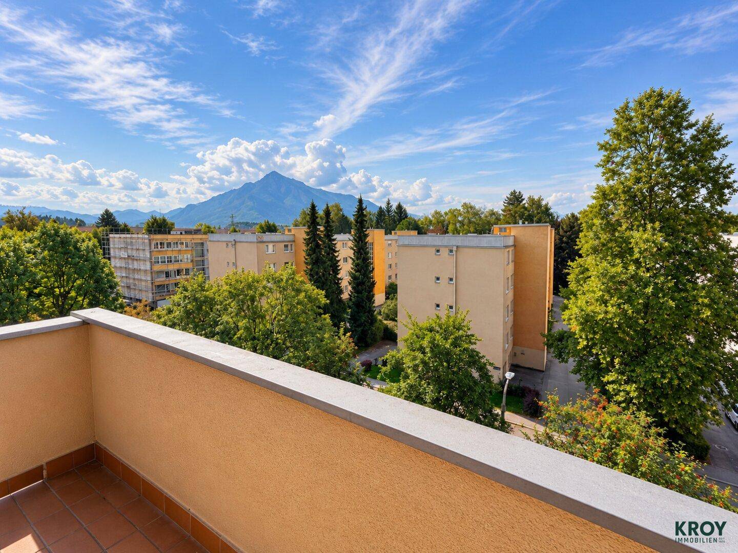 Balkon mit weitem Blick auf die umliegende Wohnbebauung und die Berge.