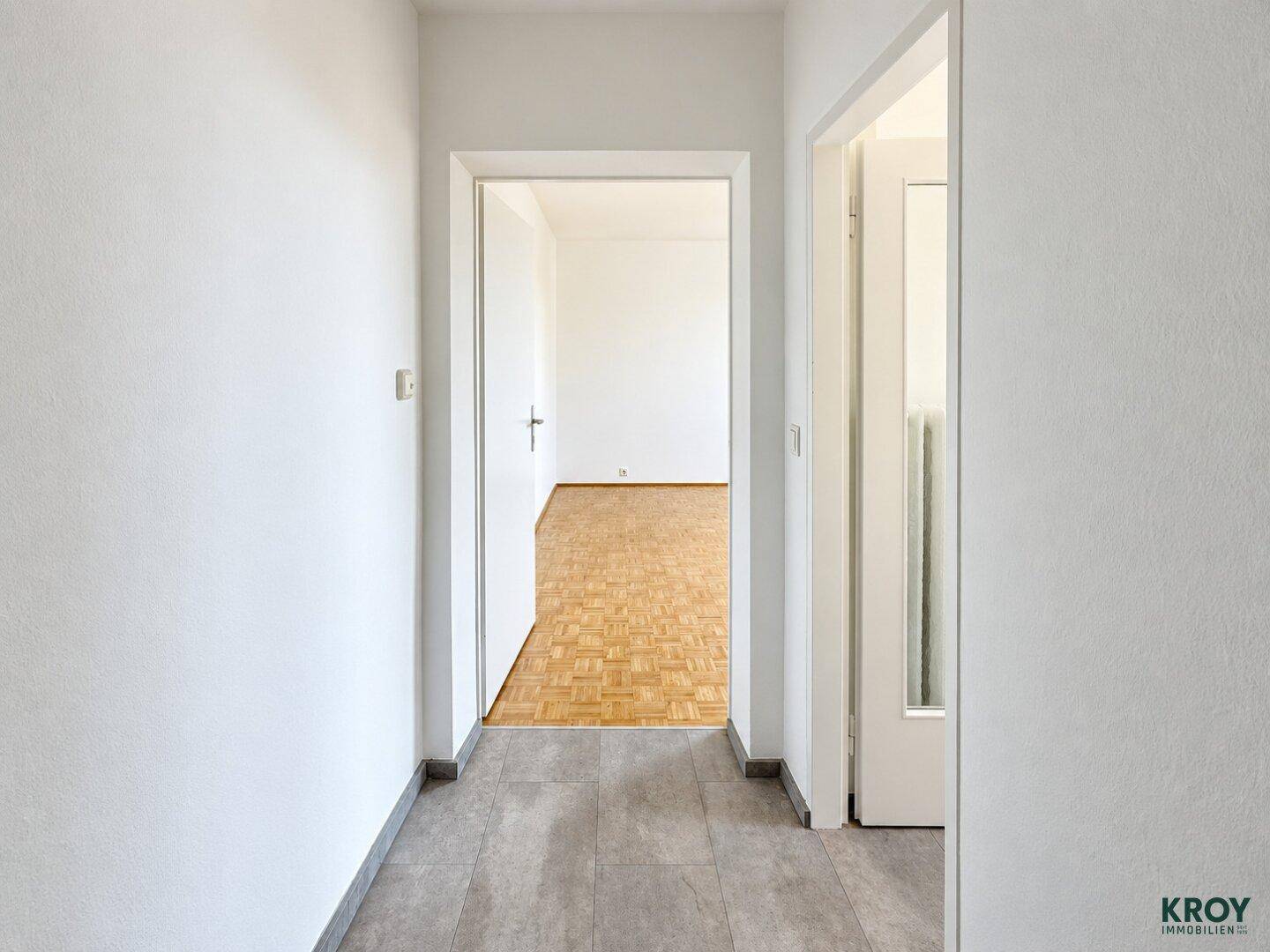 Heller Flur mit Fliesenboden und Zugang zu weiteren Zimmern.