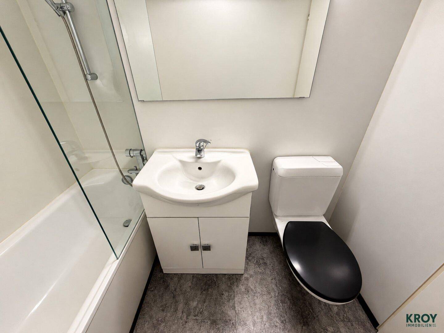 Helles Badezimmer mit Badewanne, Waschtisch und Toilette, funktional und sauber gestaltet.
