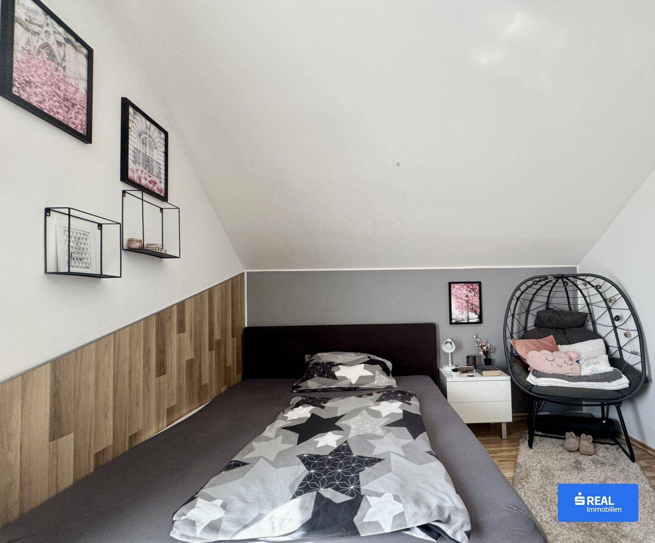 Gemütliches Schlafzimmer mit Einzelbett, Holzwand und moderner Dekoration.