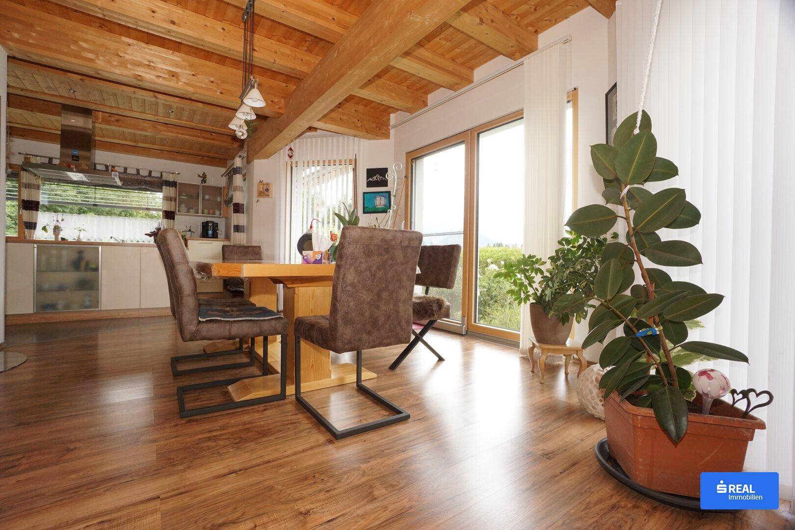 Heller Wohn-Essbereich mit Holzbalkendecke, Laminatboden und Zugang zur Terrasse.