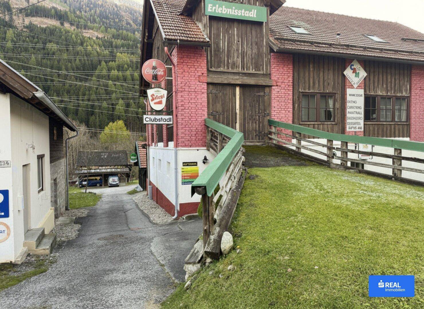 Rustikales Gebäude mit roter Ziegelfassade und Holzverkleidung, inklusive einer Zugangsrampe.