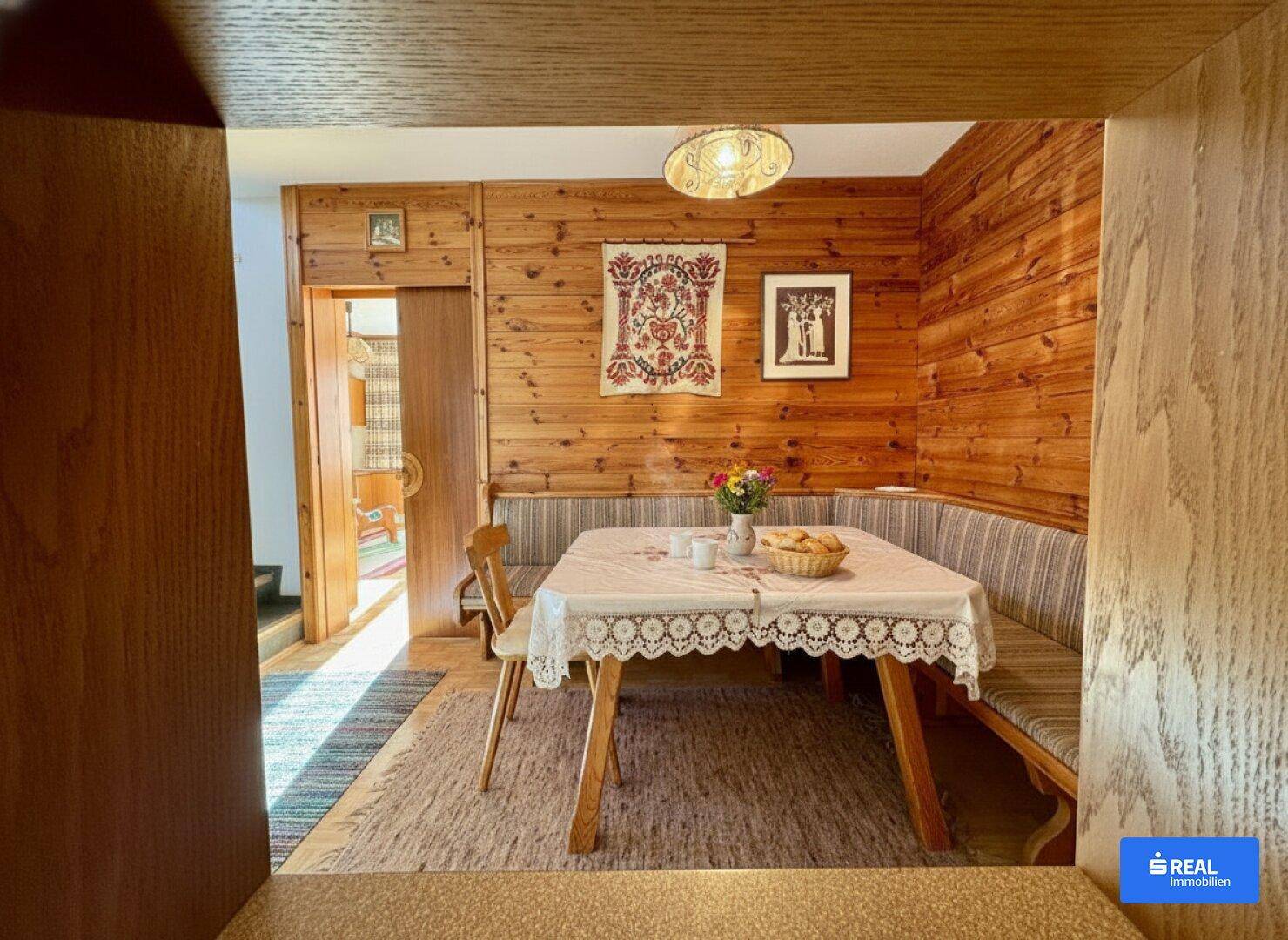 Gemütlicher Essbereich im alpinen Stil mit Holztäfelung, traditionellen Sitzbänken und einem rustikalen Tisch.