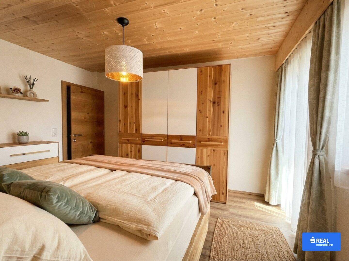 Helles Schlafzimmer mit Holzboden, großen Fenstern und einem großen Kleiderschrank.