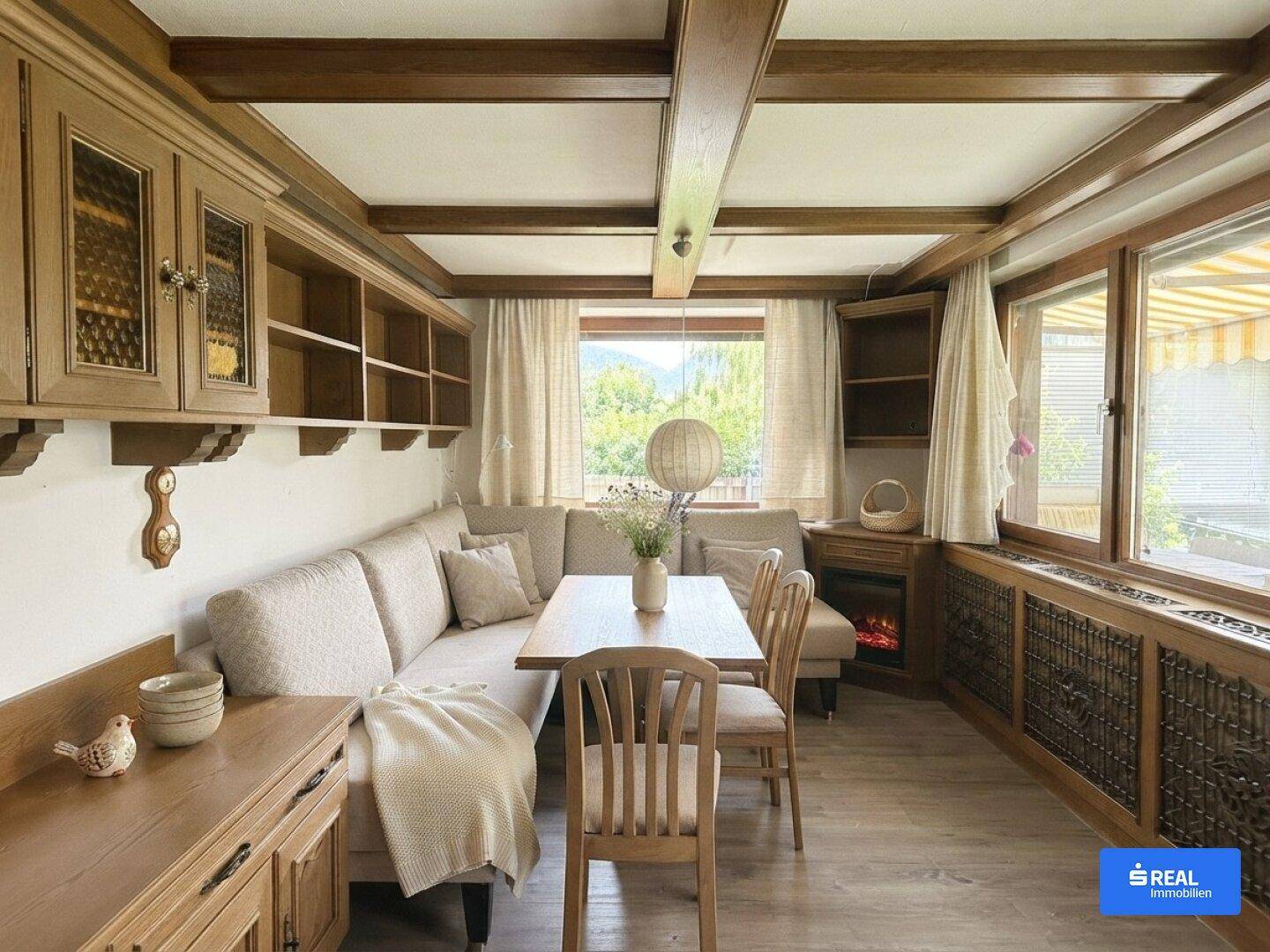 Gemütlicher Essbereich mit Holztisch, Eckbank und traditionellen Holzmöbeln unter Holzbalkendecke.