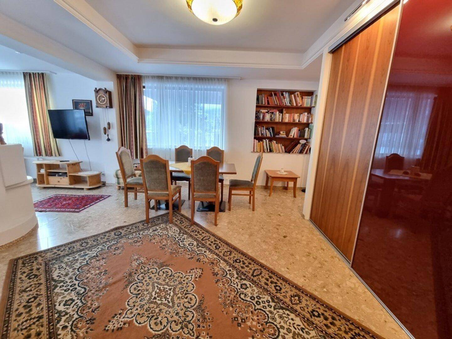 Geräumiger Wohn-Essbereich mit großem Esstisch und Blick auf den Wohnbereich.