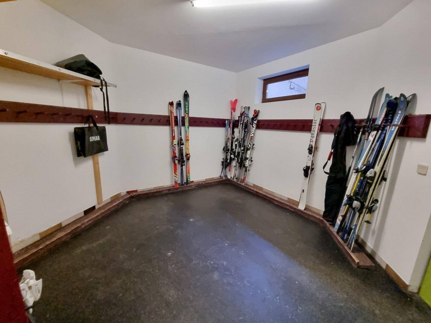 Skiraum mit Wandhalterungen für Skier und Snowboards, ideal für Wintersportler.
