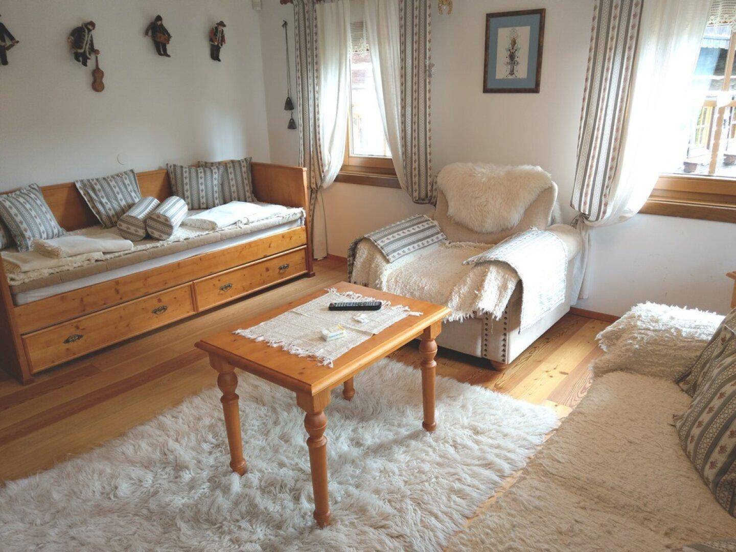Gemütliches Wohnzimmer mit Tagesbett, Sessel und Couchtisch.