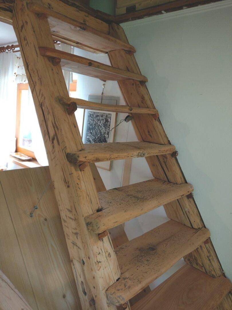 Rustikale Holztreppe, die zu einem oberen Bereich führt.