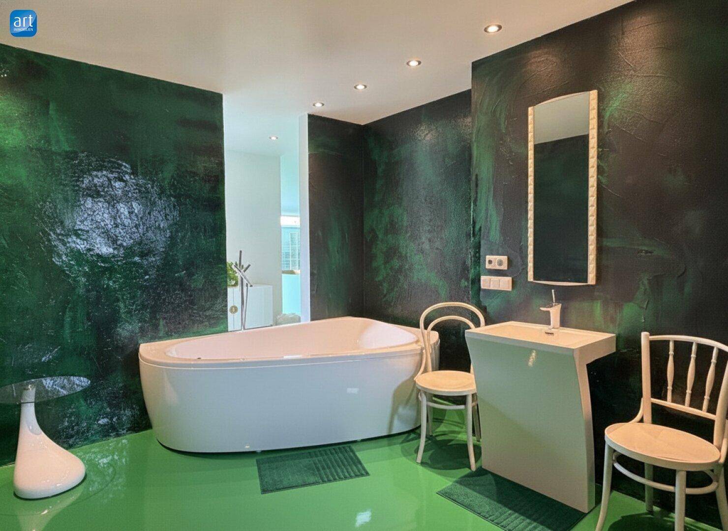 Auffälliges Badezimmer mit dunkelgrünen Wänden, freistehender Badewanne und modernem Waschtisch.