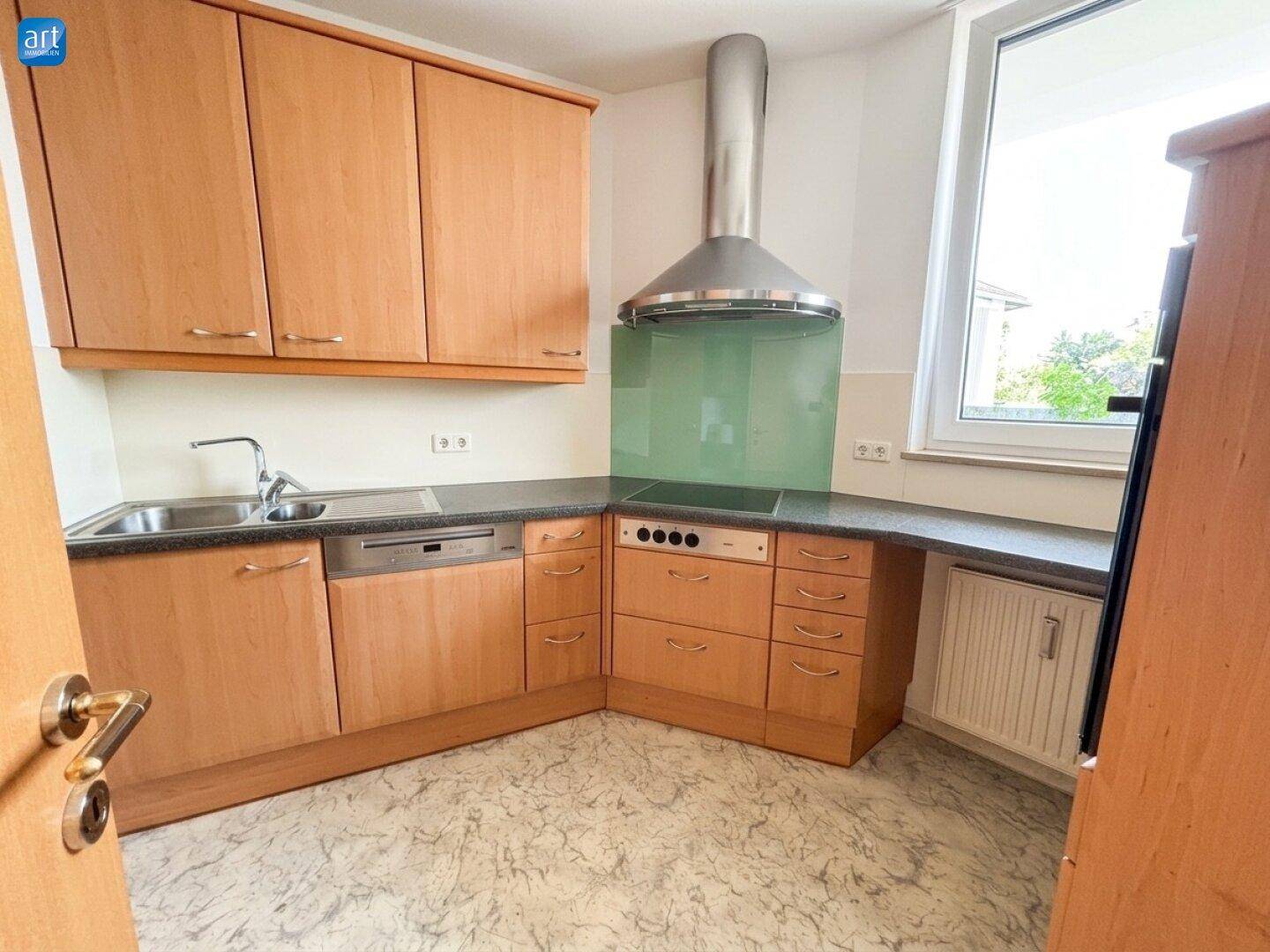 Helle Küche mit Holzfronten, Spülmaschine und Induktionskochfeld, gut ausgestattet für den Alltag.