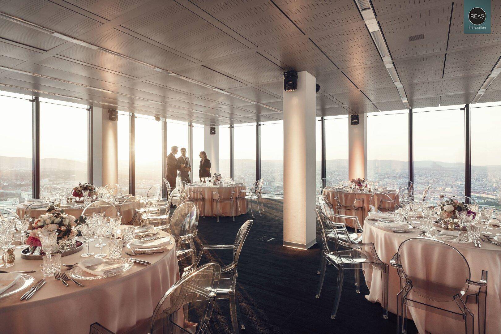 Festlich gedeckter Speisesaal im Obergeschoss mit eleganten Tischen und Stadtblick.
