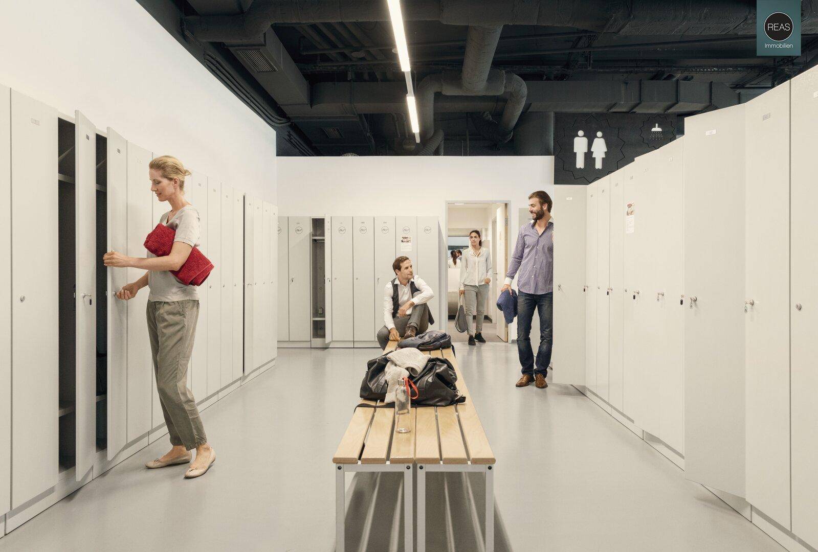 Moderner Umkleideraum mit vielen Spinden, Sitzbänken und Zugang zu den Toiletten.