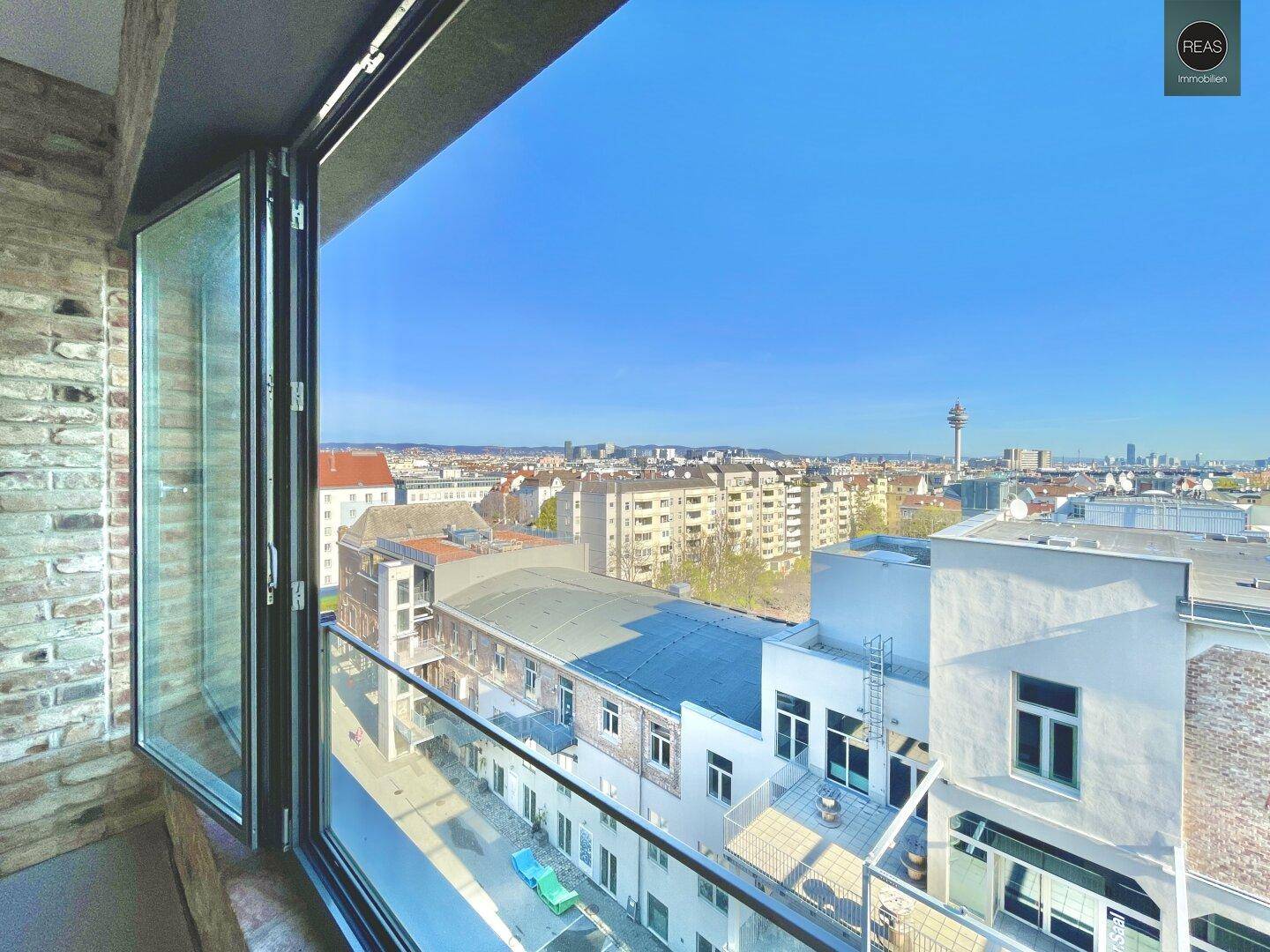 Weitläufiger Stadtblick durch ein großes Fenster, das sich öffnen lässt und die städtische Umgebung zeigt.