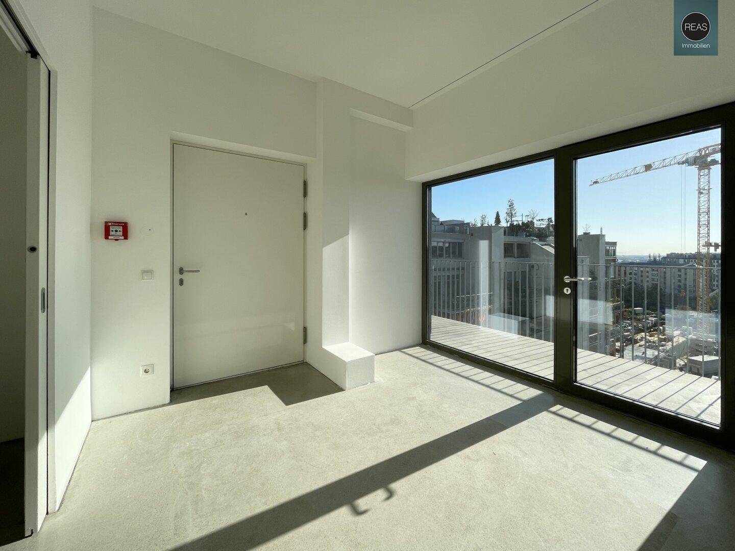 Heller Eingangsbereich mit großen Fenstern, die einen weiten Blick über die Stadt bieten.