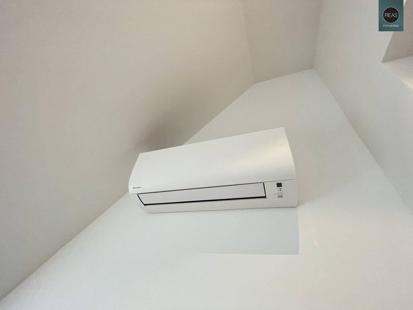 Nahaufnahme einer modernen Klimaanlage an einer weißen Wand.