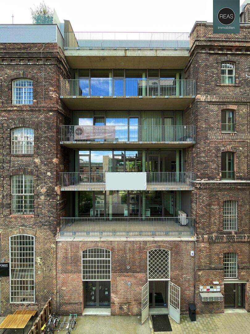 Historisches Backsteingebäude mit modernen Balkonen und großen Fenstern, die den Charakter bewahren.