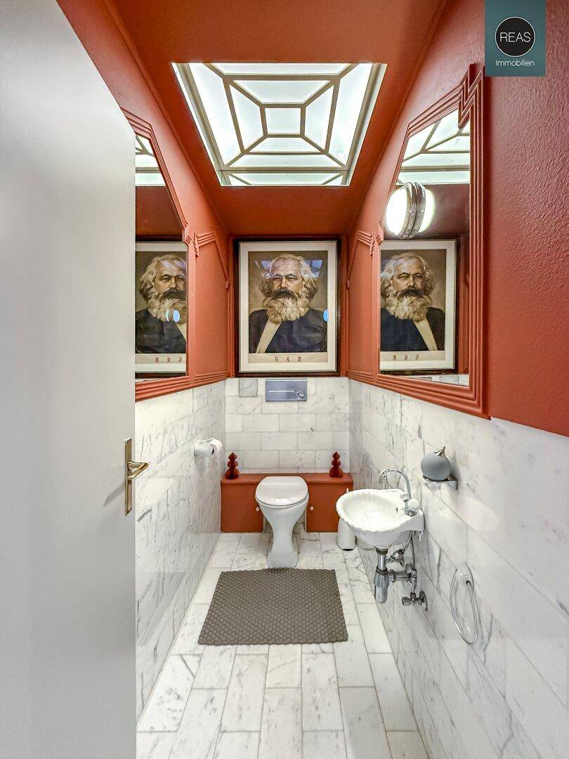 Auffälliges Gäste-WC mit Marmorfliesen, roter Decke und einem Oberlicht, das für Helligkeit sorgt.