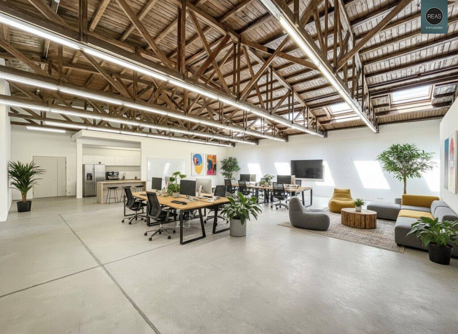 Moderner Bürobereich mit Arbeitsplätzen, gemütlicher Lounge und einer voll ausgestatteten Küche.