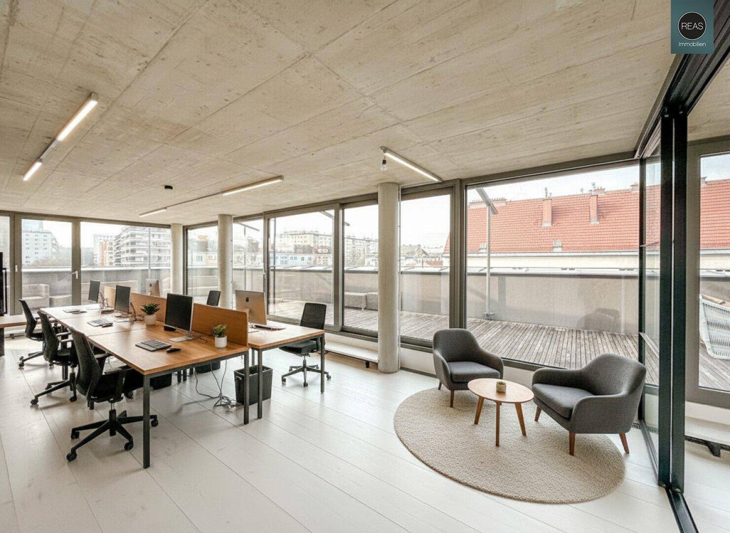 Heller Bürobereich mit Schreibtischen, Sitzgelegenheiten und direktem Zugang zur weitläufigen Dachterrasse.