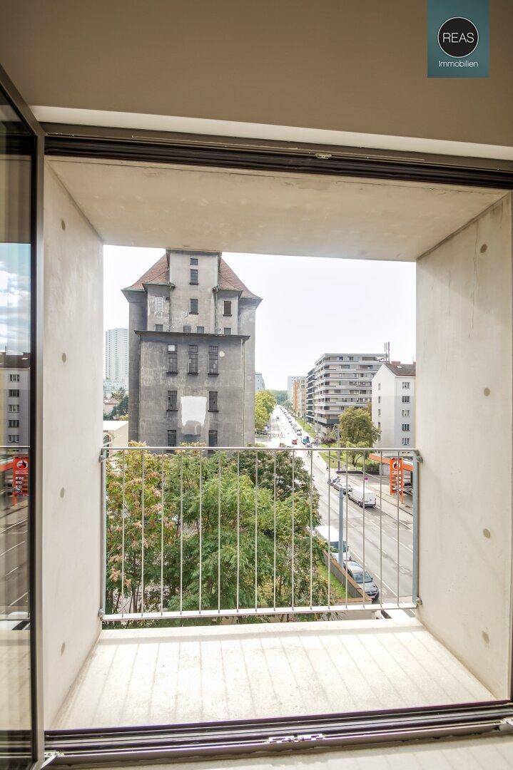 Blick vom Balkon auf die belebte Straße und umliegende Stadtgebäude.