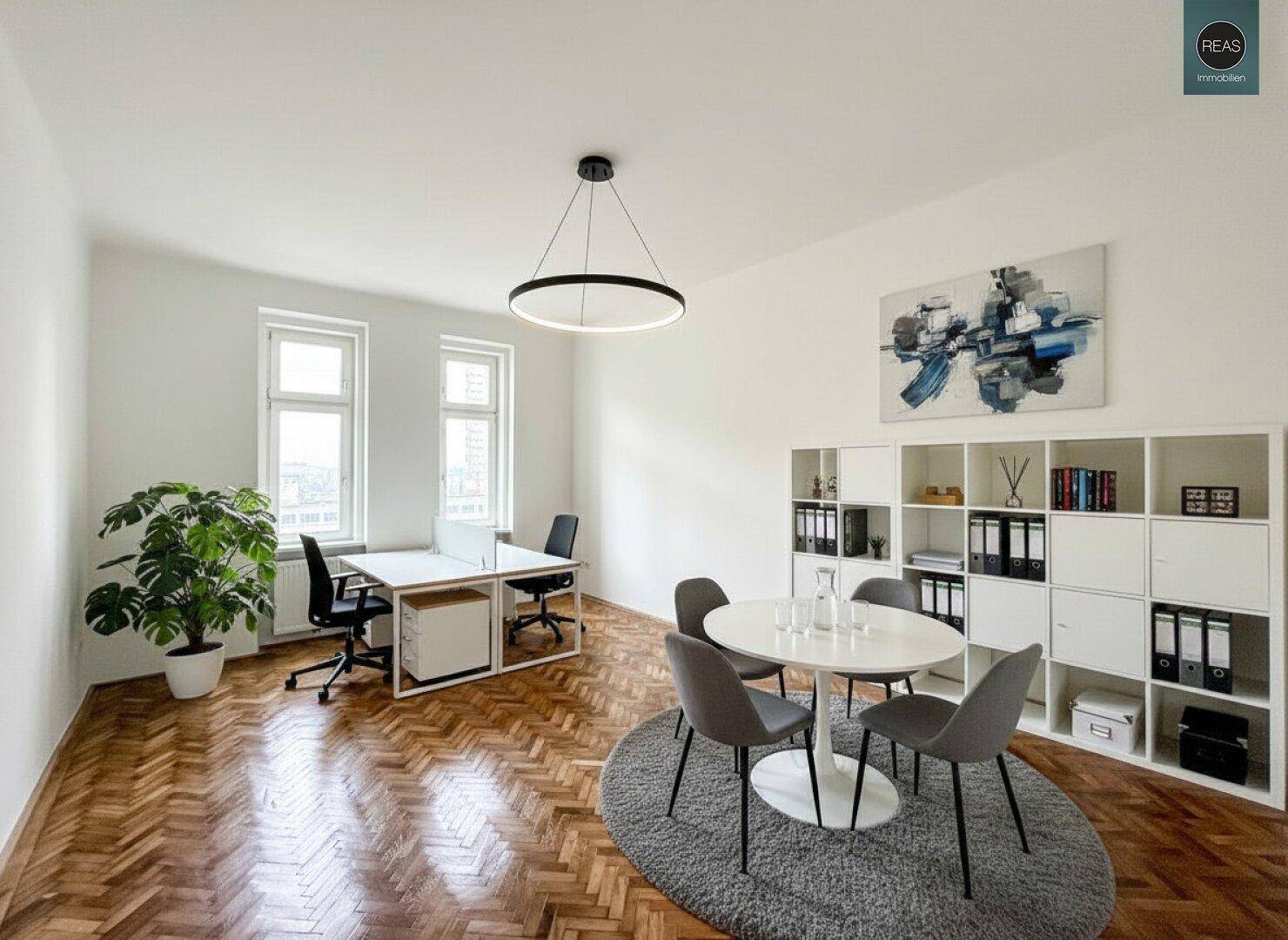 Modern eingerichtetes Büro mit Fischgrätparkett, mehreren Arbeitsplätzen und einem runden Besprechungstisch.