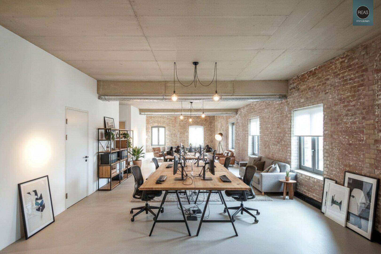Geräumiges, modernes Büro im Loft-Stil mit freiliegenden Ziegelwänden, hohen Decken und offener Arbeitsfläche.