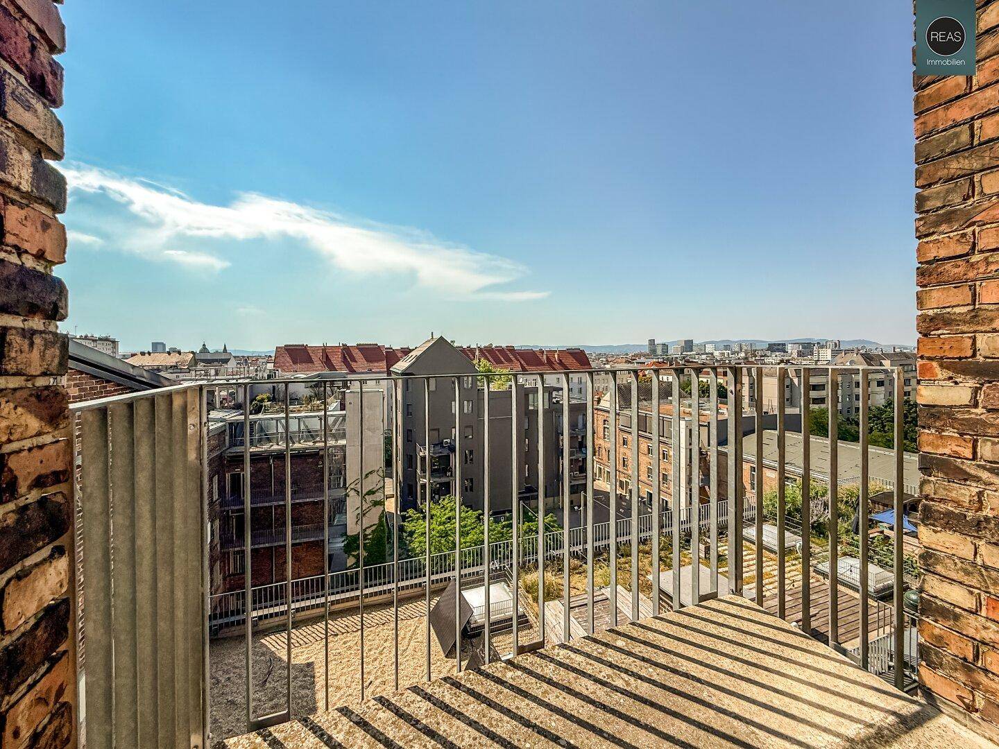 Kleiner Balkon mit Ziegelwänden und Metallgeländer bietet einen weiten Blick über die Stadt.