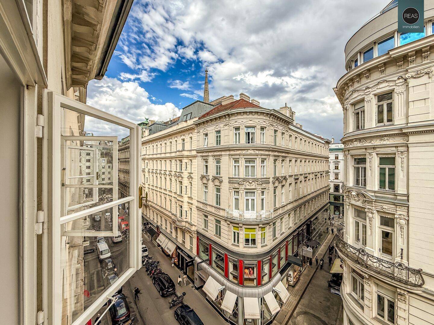 Weitläufiger Blick aus dem Fenster auf die historische Stadtarchitektur und das geschäftige Treiben auf der Straße.