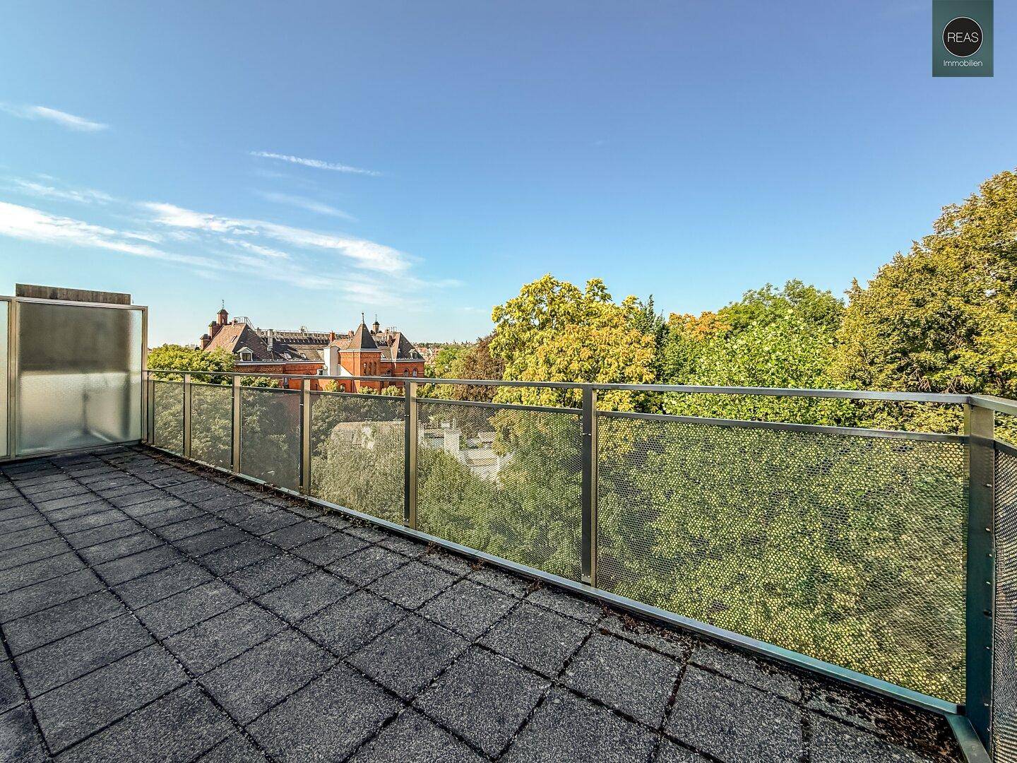 Geräumige Dachterrasse mit Fliesenboden und weitem Blick ins Grüne und auf die Stadt.