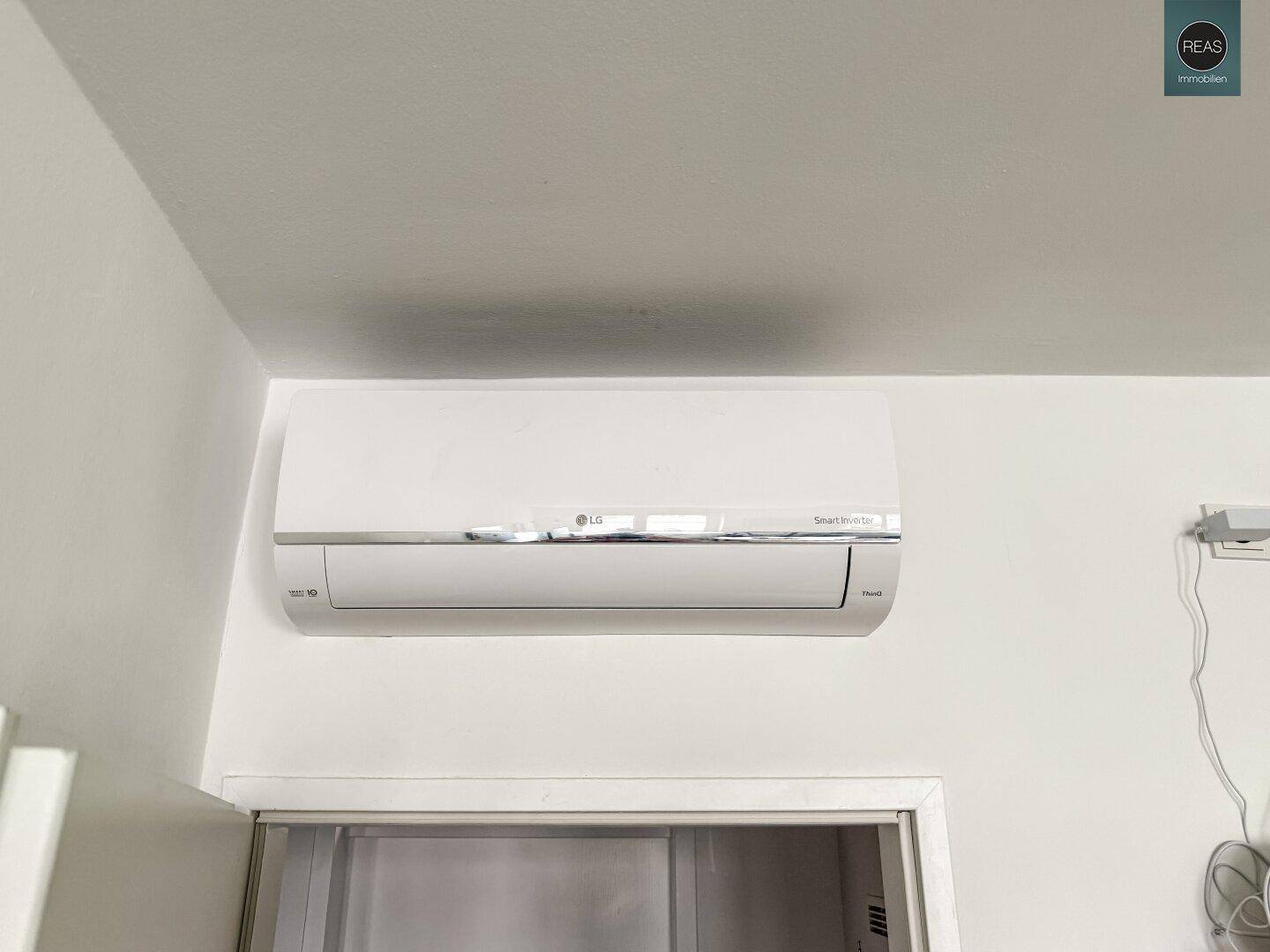 Nahaufnahme einer modernen LG Klimaanlage, an einer weißen Wand montiert.