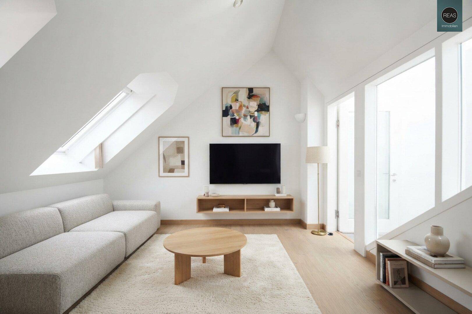 Modernes Wohnzimmer im Dachgeschoss mit Dachschrägen, hellem Sofa und Holzboden.