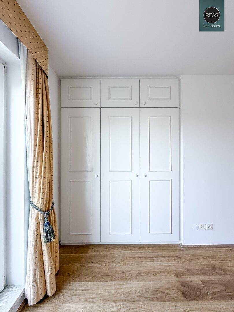 Weiße Einbauschränke im Schlafzimmer bieten viel Stauraum und eine aufgeräumte Optik.