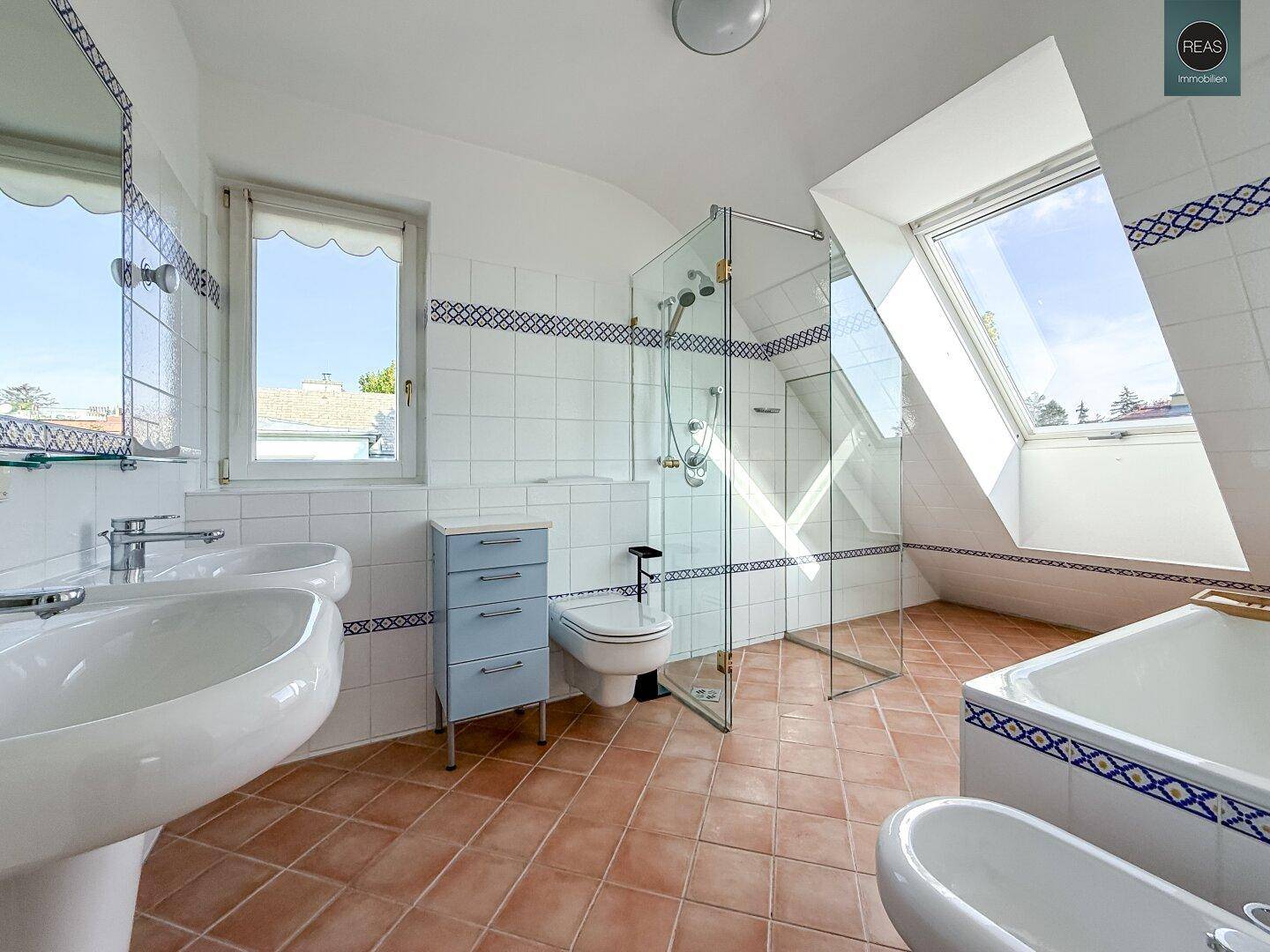 Geräumiges Badezimmer im Dachgeschoss mit Dusche, Badewanne, Bidet und Dachfenster.