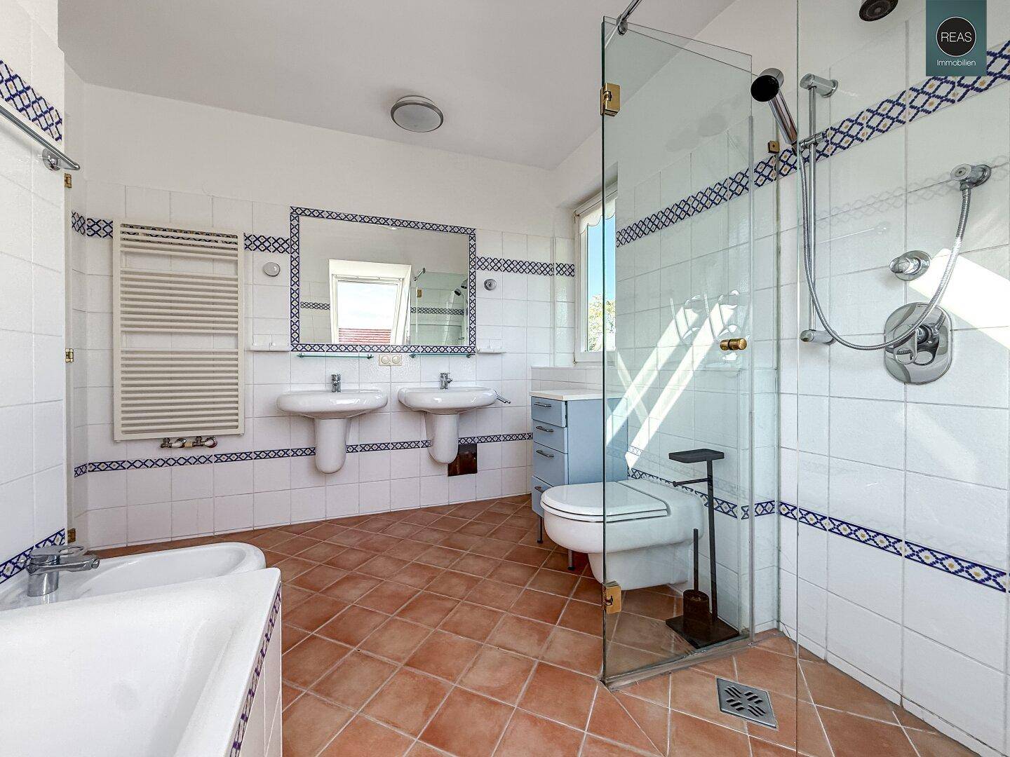 Großes Badezimmer im Dachgeschoss mit zwei Waschbecken, Dusche, Badewanne und Bidet.