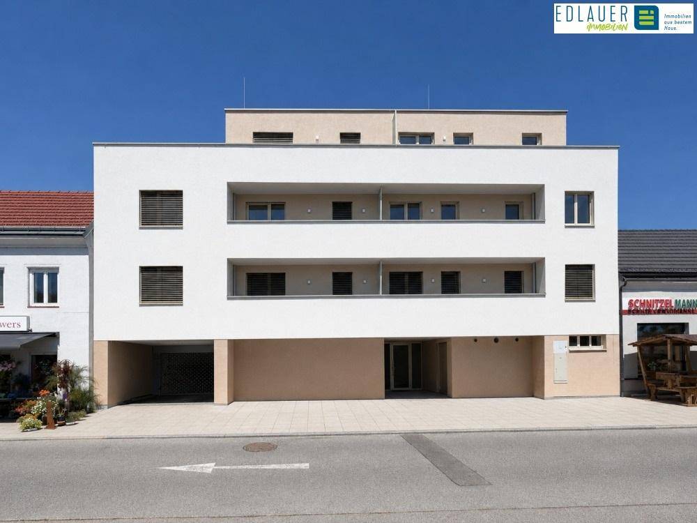 Vorderansicht eines modernen Mehrfamilienhauses mit klarer Architektur und Balkonen.