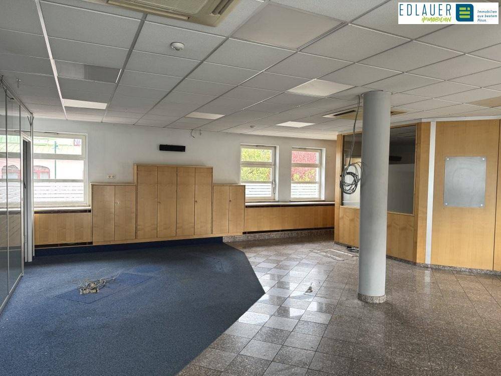 Geräumiges Büro mit Teppichboden und Fliesen, Einbauschränken und abgehängter Decke.