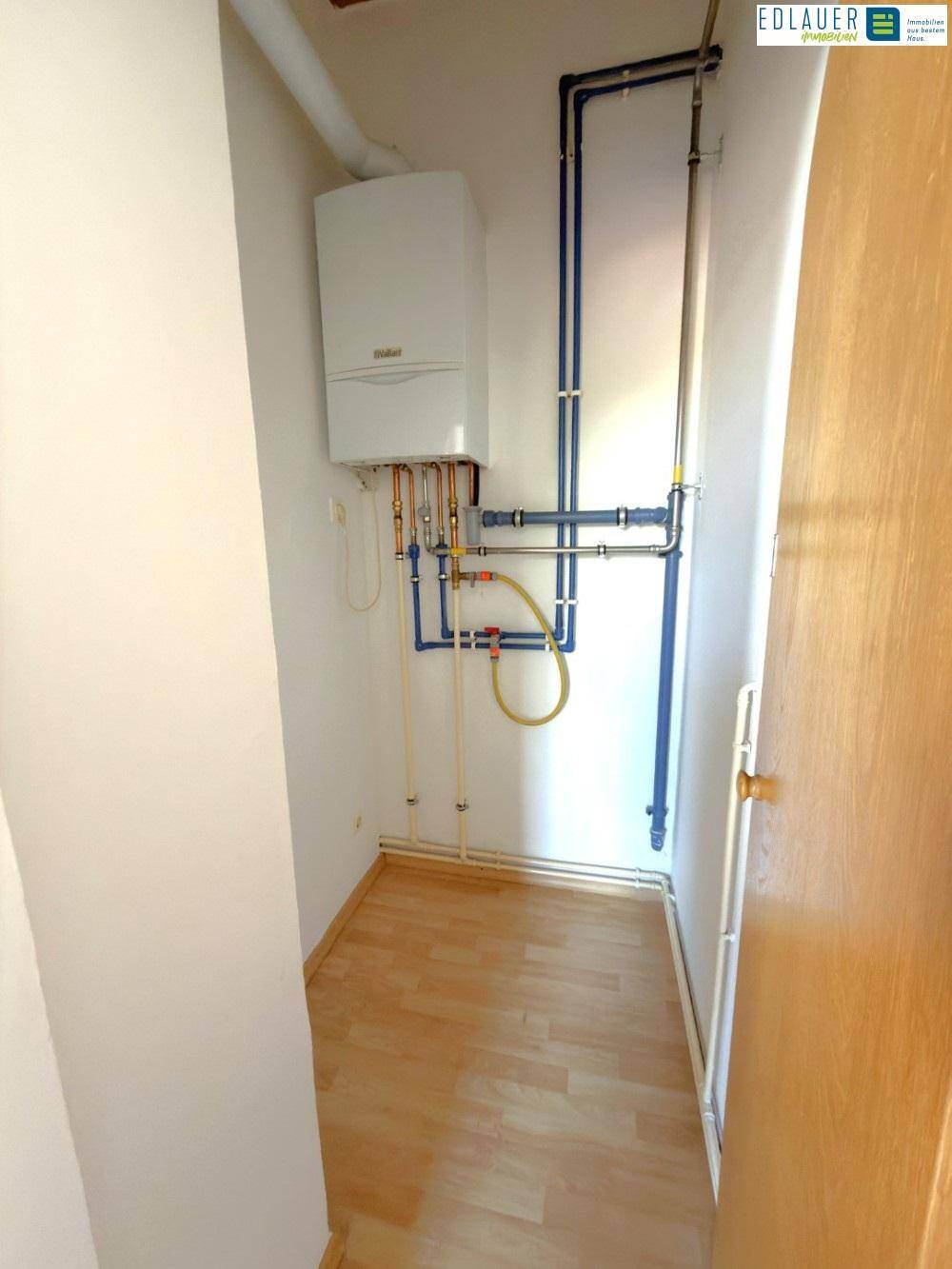 Kleiner Hauswirtschaftsraum mit Gastherme und sichtbaren Rohrleitungen, praktisch für Technik.