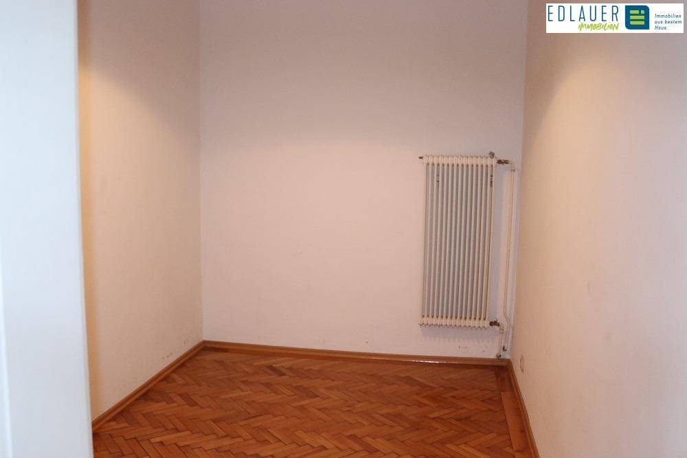 Kleiner Raum mit Fischgrätparkett und einem Heizkörper, geeignet als Abstellraum oder kleines Büro.