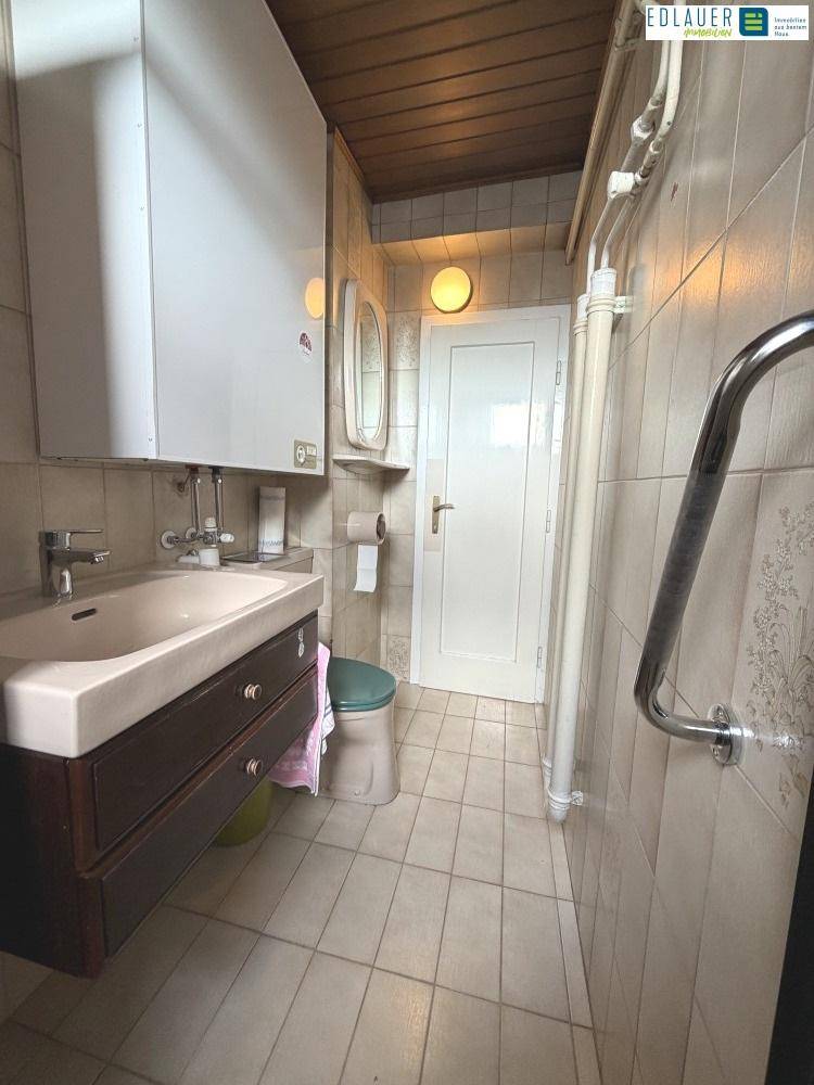Funktionales Badezimmer mit Waschbecken, Spiegelschrank und Fliesenboden, bietet grundlegende Ausstattung.