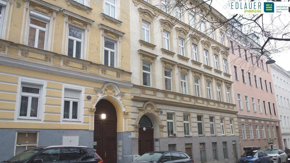 Historische Fassade eines Altbaus mit reich verzierten Fenstern und Details.