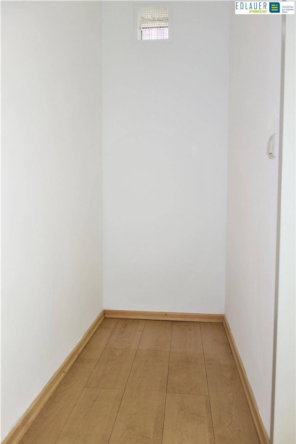 Kleiner Abstellraum mit Parkettboden und einer Lüftungsöffnung an der Decke.