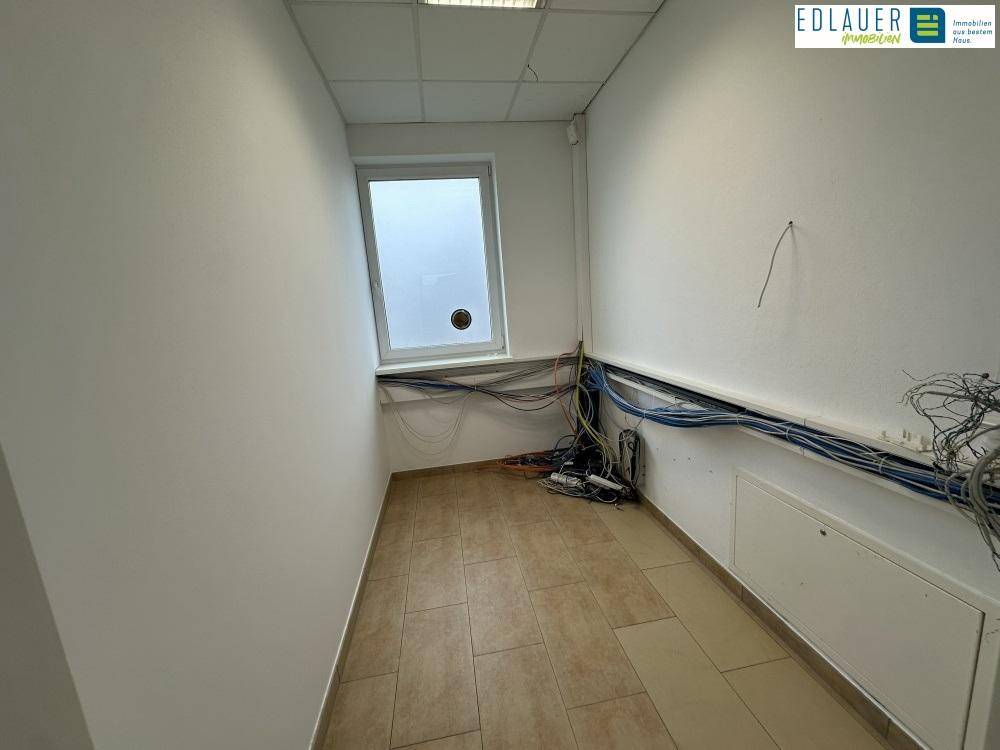 Kleiner Raum mit umfangreicher Verkabelung und Fenster, ideal als Serverraum oder Technikzentrale.