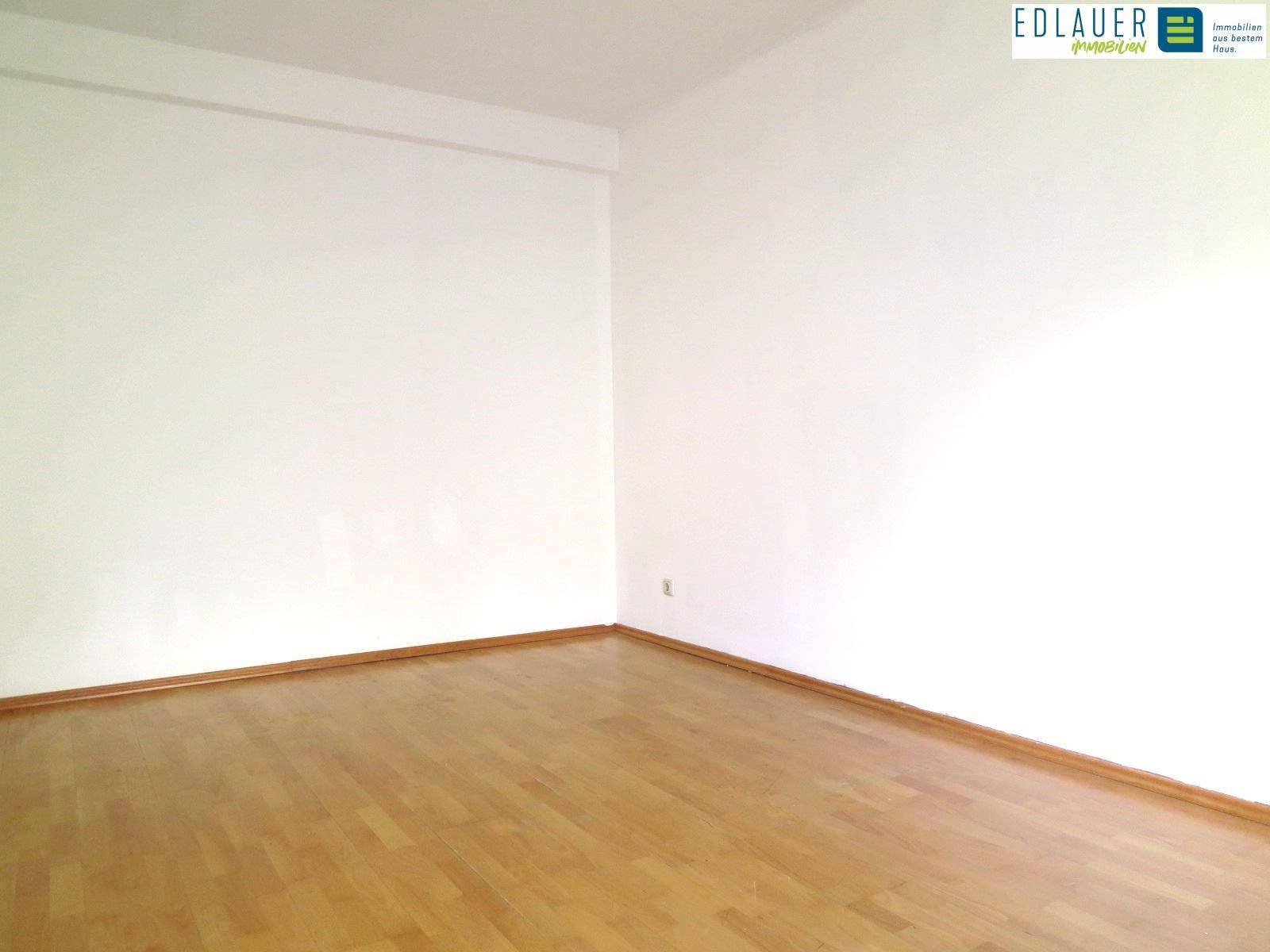 Heller Raum mit Parkettboden und weißen Wänden, bereit zur individuellen Einrichtung.