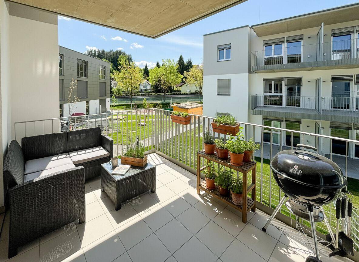 Geräumiger Balkon mit Sitzgelegenheiten, Pflanzen und Grill, mit Blick auf die Umgebung.